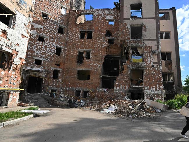 A woman walks past a destroyed residential building in the town of Irpin, northwest from Ukrainian capital of Kyiv. Picture: AFP