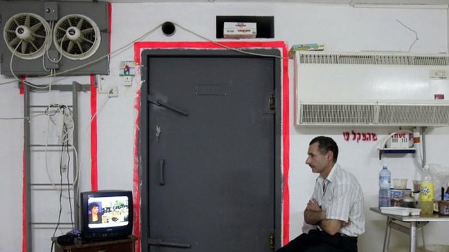 An Israeli man watches the news of Israel's ceasefire with Lebanon on public television while sitting in a bomb shelter during rocket attacks in the northern Israeli city of Nahariya. Picture: AFP.