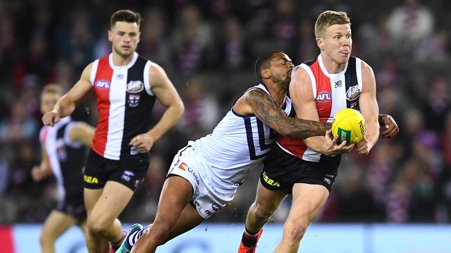 MELBOURNE, AUSTRALIA – AUGUST 11: Dan Hannebery of the Saints handballs while being tackled by Bradley Hill of the Dockers during the round 21 AFL match between the St Kilda Saints and the Fremantle Dockers at Marvel Stadium on August 11, 2019 in Melbourne, Australia. (Photo by Quinn Rooney/Getty Images)