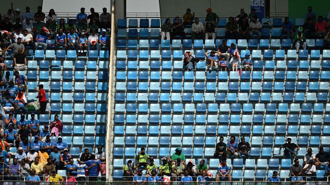 Spectators sit in partially deserted stands during the ICC Champions Trophy one-day international (ODI) cricket match between Pakistan and India at the Dubai International Stadium. (Photo by Jewel SAMAD / AFP)