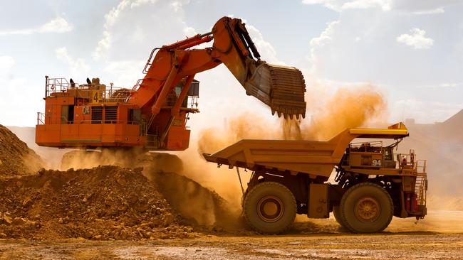 A haul truck is loaded by a digger with material from the pit at Rio Tinto’s West Angelas iron ore mine in Pilbara. Rio, BHP and Fortescue are moving fast to make sure they have a portfolio which will reflect the new realities of the market. Picture: Getty Images