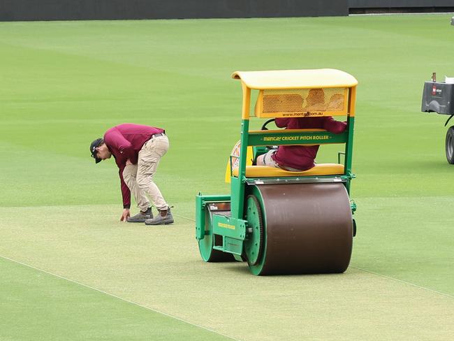 Staff work on the pitch at the Gabba as head curator David Sandurski speaks about the pitch ahead of the 3rd test starting on Saturday. Pics Adam Head