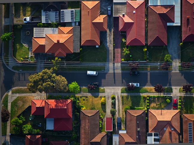 Flying over the suburbs of Melbourne; Community; Housing Development; Railroad Crossing; Crossing; Urban Scene; Aerial View; High Angle View; Melbourne - Australia; Roof; Street; Suburb; Residential District; City; Aerial Photograph. For group read story on rooming house laws. iSTOCK