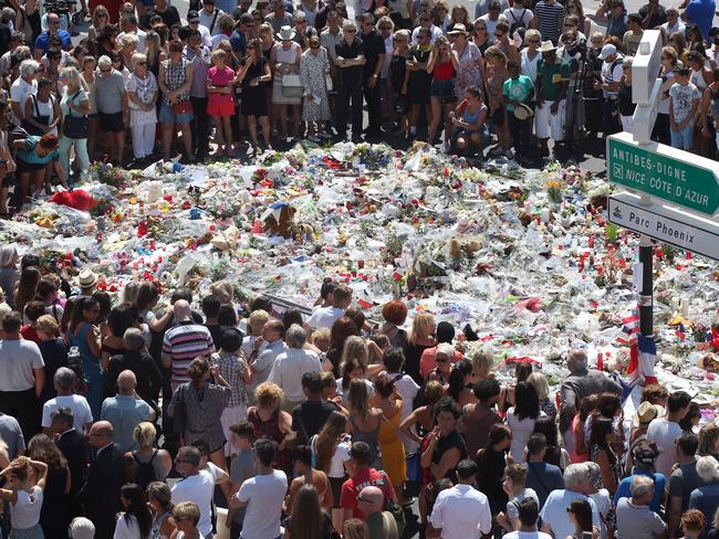 People gather at a makeshift memorial to observe a minute of silence to honour the victims of the attack I in Nice. Picture: AP Photo/Luca Bruno.