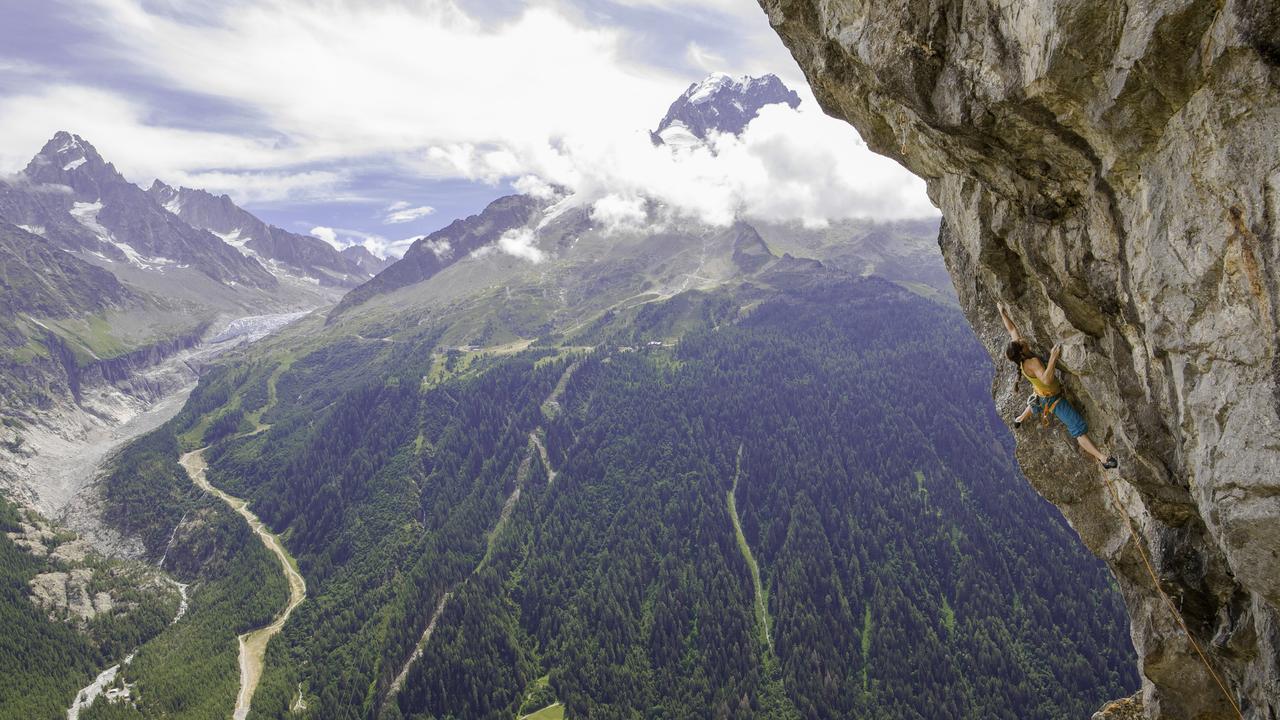 A woman scales a rock face in the Alps. Many guides and climbers report scary encounters with crumbling rock.