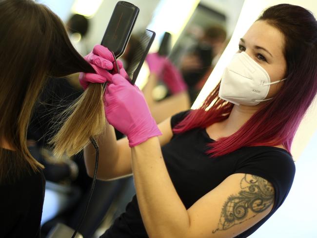 A hairdresser wears a face mask and gloves to protect against the coronavirus in a salon in Italy, with the country reopening restaurants and shops closed during the coronavirus crisis. Picture: AP Photo