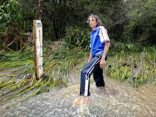 Glens Creek Rd resident Andrew Porelli in the flooded causeway which regularly blocks the road. . Picture: JOJO NEWBY