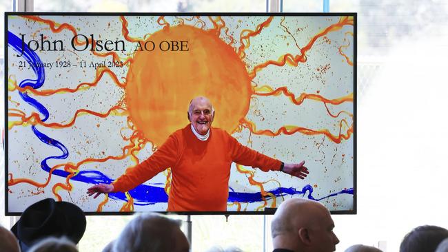 A photograph of John Olsen and one of his paintings is seen during a State Memorial. Picture: NCA NewsWire / pool / Jenny Evans