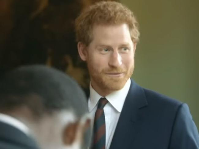 Prince Harry is seen joking with visitors that he and the other royals ‘panic’ when they bump into the Queen in the corridor.