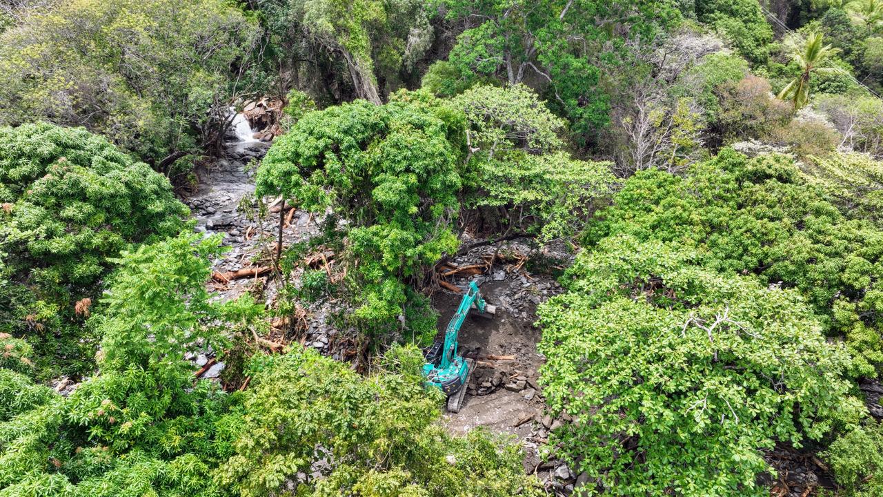 An excavator cleans debris from a huge landslide at Ellis Beach. Picture: Brendan Radke
