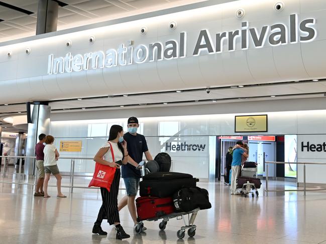 Passengers wearing PPE, including a face mask as a precautionary measure against COVID-19, walk through the arrivals hall after landing at London’s Heathrow Airport. Picture: AFP