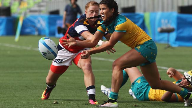 RIO DE JANEIRO, BRAZIL — AUGUST 07: Charlotte Caslick of Australia passes the ball under pressure from Alev Kelter of the United States during the Women's Pool A rugby match on Day 2 of the Rio 2016 Olympic Games at Deodoro Stadium on August 7, 2016 in Rio de Janeiro, Brazil. (Photo by David Rogers/Getty Images)