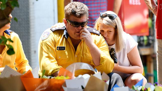 A Horsley Park RFS member is comforted at a memorial for fellow volunteers Geoff Keaton and Andrew O’Dwyer. Picture: AAP