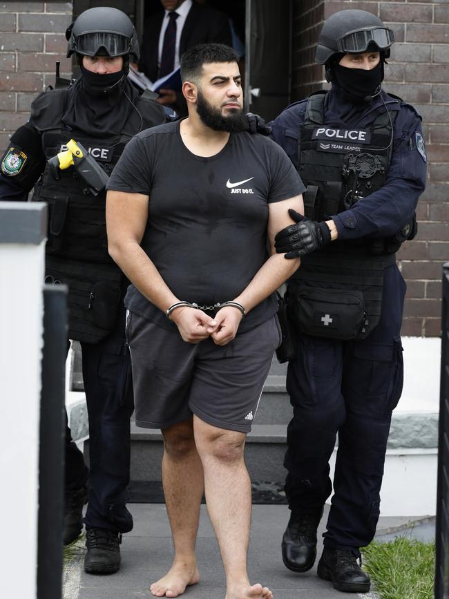 A barefoot Omar Fawaz Mahfouz is led away in handcuffs.