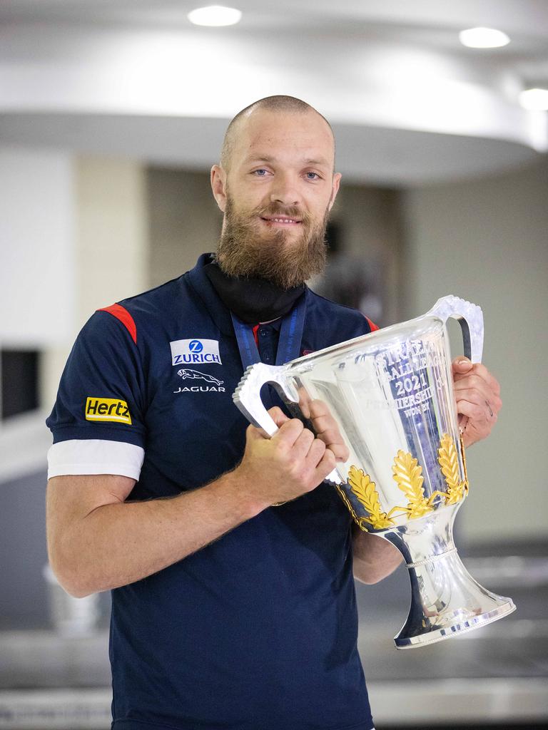 Max Gawn shows off the silverware after arriving back in Melbourne.