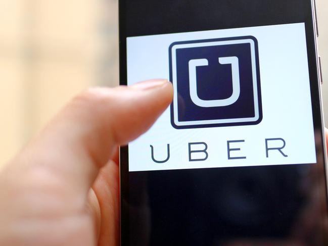 --FILE--A mobile phone user shows the logo of car-hailing app Uber on his smartphone in Chengdu city, southwest China's Sichuan province, 6 May 2015.  U.S. firm Uber Technologies Inc and Chinese rival Didi Kuaidi are taking steps to operate legally in China, a key market for both firms but where their car hailing services currently operate in a regulatory prey zone. Uber China said in a statement on Thursday (8 October 2015) it was "actively preparing" documents to apply for a license to operate an online car-hailing platform to meet new regulations governing the sector that are expected to be announced soon. Didi Kuaidi, a $16 billion valued firm backed by Chinese Internet giants Alibaba Group Holding Ltd and Tencent Holdings Ltd, also said on Thursday it had received a car booking license for its operations in Shanghai and that it was seeking more licenses from other cities.