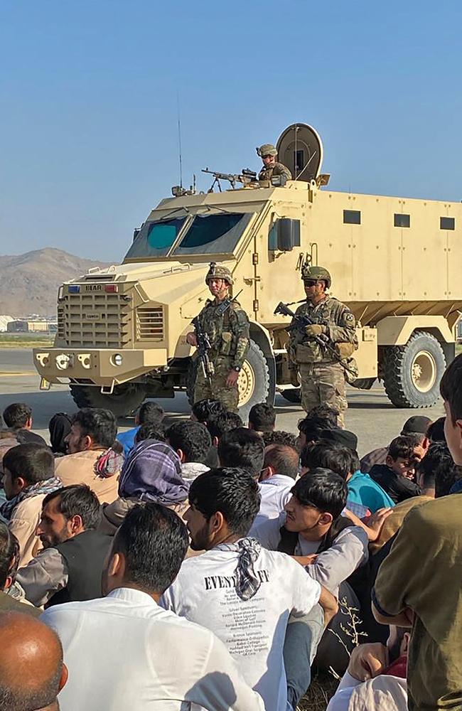 Afghans crowd at the airport as US soldiers stand guard. Picture: AFP