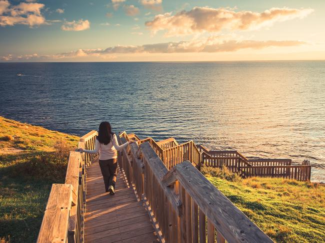 Woman walking down Hallett Cove boardwalk to enjoy sunset from beach, South Australia. Picture: iStockWalks cover story, Escape, laura waters