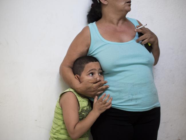 An Israeli woman and her son take cover as a siren sounds during a rocket attack fired by Palestinians militants from Gaza, in Tel Aviv, Israel. Picture: Oded Balilty