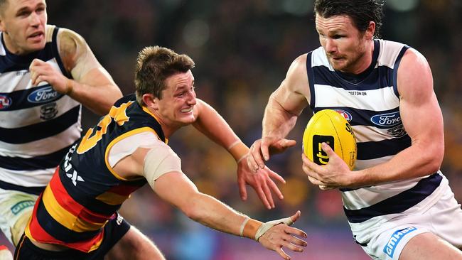 Patrick Dangerfield of the Cats under pressure from Adelaide’s Matt Crouch on Thursday night. Picture: Daniel Kalisz/Getty Images