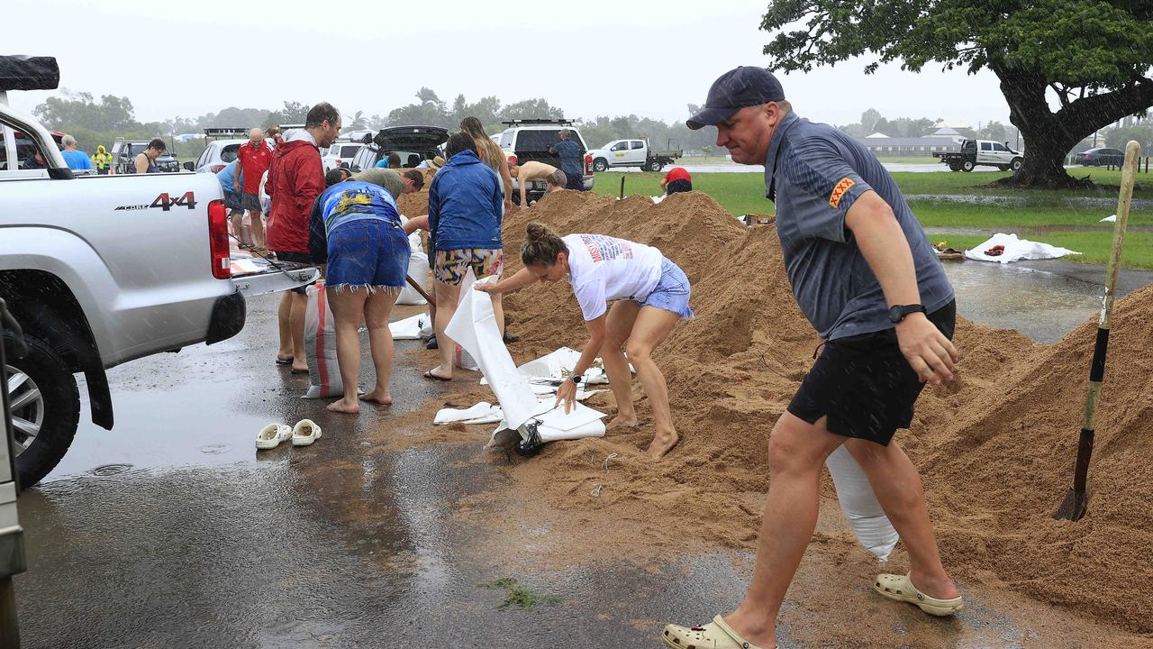 Residents collect sand bags as Police begin door knocking homes in Railway Estate on Saturday. Picture: Adam Head