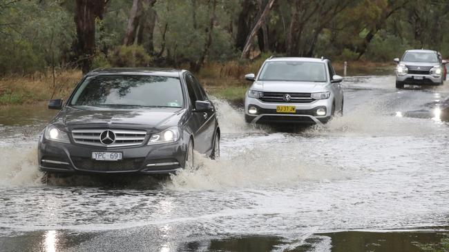 Cars drive through floodwater on the Epsom-Barnadown Rd near Bendigo. Picture: David Crosling