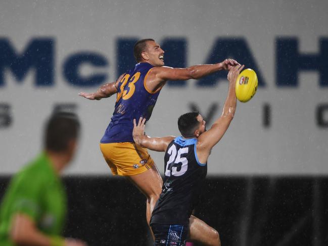 Wanderers ruck Mathew Motlop flys over Buffalo's player Christopher Atkinson in round 1 of the NTFL 22/23 season. Picture: (A)manda Parkinson