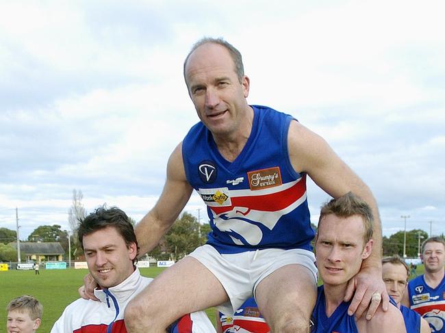 Simon Goosey is chaired off the ground by his Mornington teammates Chris Holcombe (left) and Murray Peel in 2005. Picture: Chris Eastman