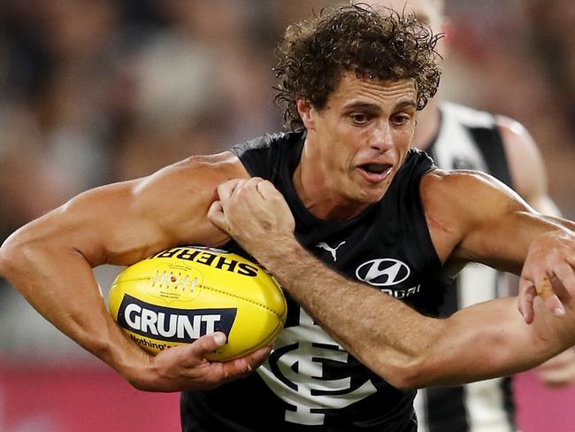 MELBOURNE, AUSTRALIA - MARCH 25: Ed Curnow of the Blues is tackled by Steele Sidebottom of the Magpies during the 2021 AFL Round 02 match between the Carlton Blues and the Collingwood Magpies at the Melbourne Cricket Ground on March 25, 2021 in Melbourne, Australia. (Photo by Dylan Burns/AFL Photos via Getty Images)