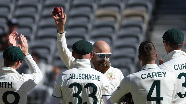 Australia's Nathan Lyon celebrates with teammates after taking his 500th wicket in Test cricket. Picture: Colin Murty / AFP.