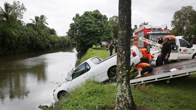 Crocs are not the only occasional unwanted residents of the creek. Police officers and tow truck operators removed a white Holden Commodore utility from the stormwater drain back in 2017. Picture: BRENDAN RADKE