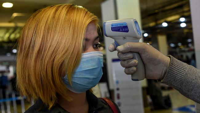 A health services staff member checks the body temperature of a passenger at the Hamid Karzai International Airport in Kabul. Afghan health authorities are establishing isolation wards across the country ahead of a potential influx of coronavirus cases as governments worldwide monitor the disease's Picture: AFP.