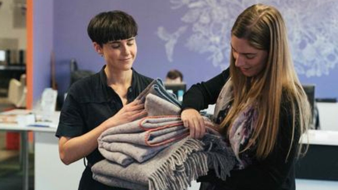 Karina Seljak inspects one of their recycled textile blankets.