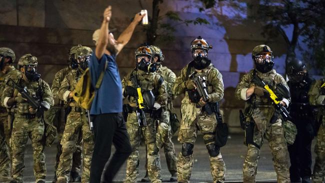 Federal police stand guard in the centre of Portland, Oregon, after pushing protesters away from a courthouse building on Tuesday night. Picture: Getty Images