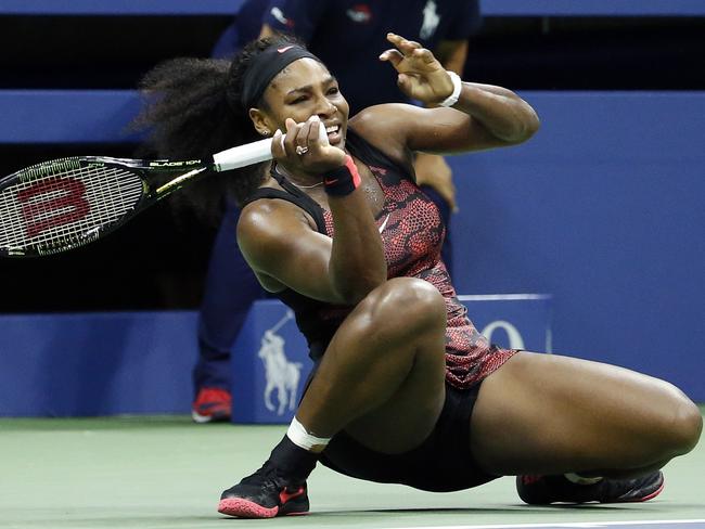 Serena Williams falls to the court as she follows through on a shot to Venus Williams during a quarter-final match at the U.S. Open.