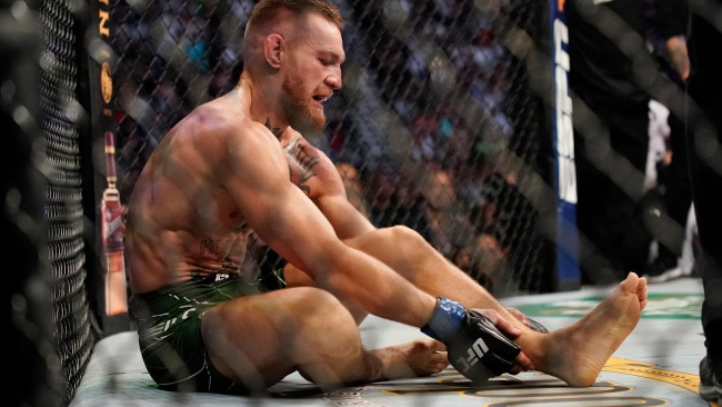 Conor McGregor holds his left ankle while fighting Dustin Poirier during UFC 264. AP Photo/John Locher