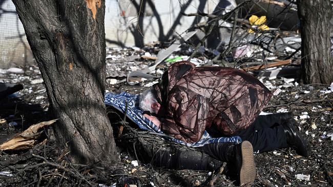 A man weeps over the body of a relative outside a destroyed building after bombings on the eastern Ukraine town of Chuguiv.