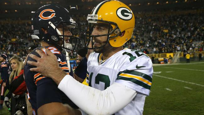 Quarterback Aaron Rodgers #12 of the Green Bay Packers meets with quarterback Matt Barkley #12 of the Chicago Bears.