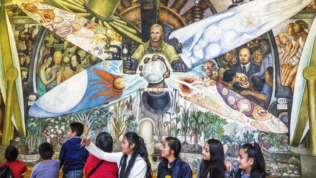 Students take selfies with Diego Rivera’s mural Man, Controller of the Universe, at the Palace of Fine Arts in Mexico City. Picture: Rosie Irene Betancourt/Getty Images