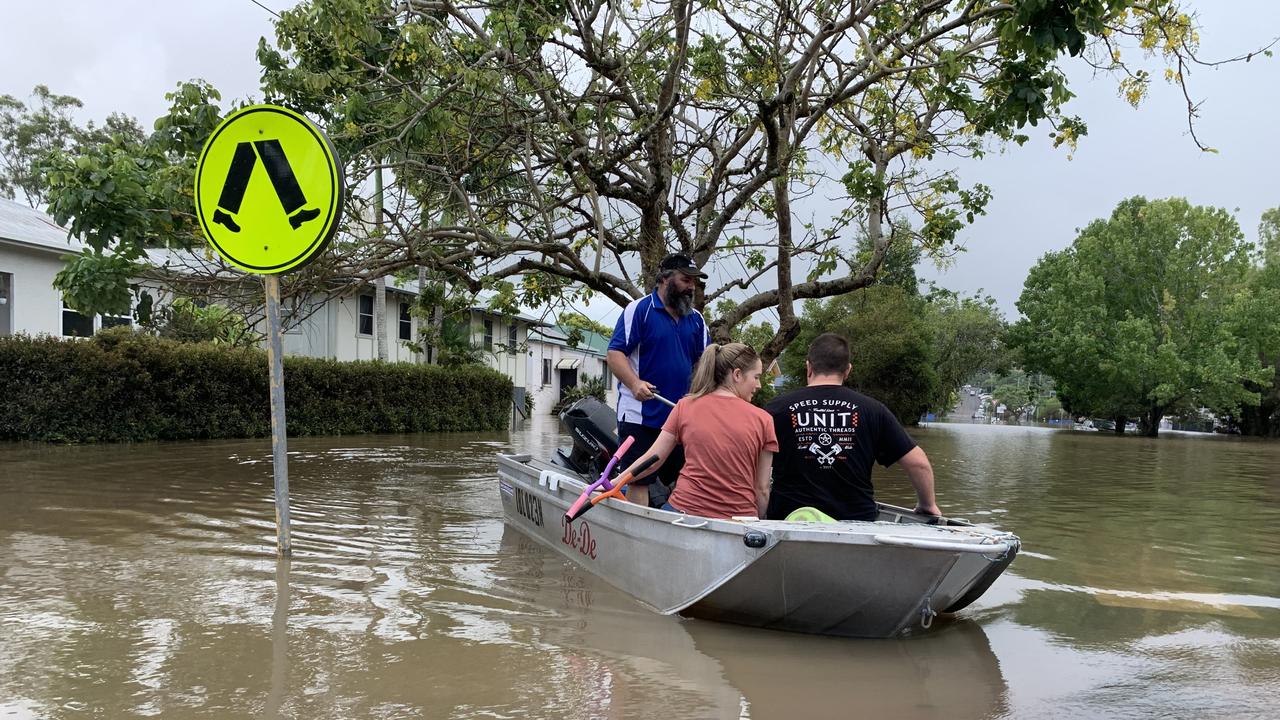 Max Walker paddles for Steve and Bianca Bennett after taking them to their flooded Hunter Street home on March 1, 2022, a day after Lismore was hit by a record flood. Picture: Stuart Cumming