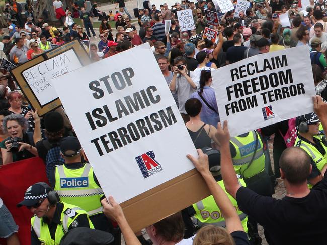 Police try to keep protesters apart in front of Flinders station after a rally at Federation sq where Anti-racist campaigners confront the newly formed anti-Muslim group 'Reclaim Australia' at Federation Square in Melbourne. Saturday, April 4. 2015. Picture: David Crosling