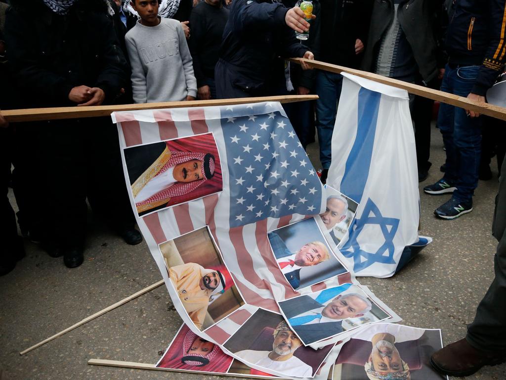 Angry Palestinian Fatah movement supporters prepare to set US and Israeli flags on fire, along with portraits of US President Donald Trump, Israeli Premier Benjamin Netanyahu and Gulf Arab leaders during a protest against a US peace plan. Picture: AFP