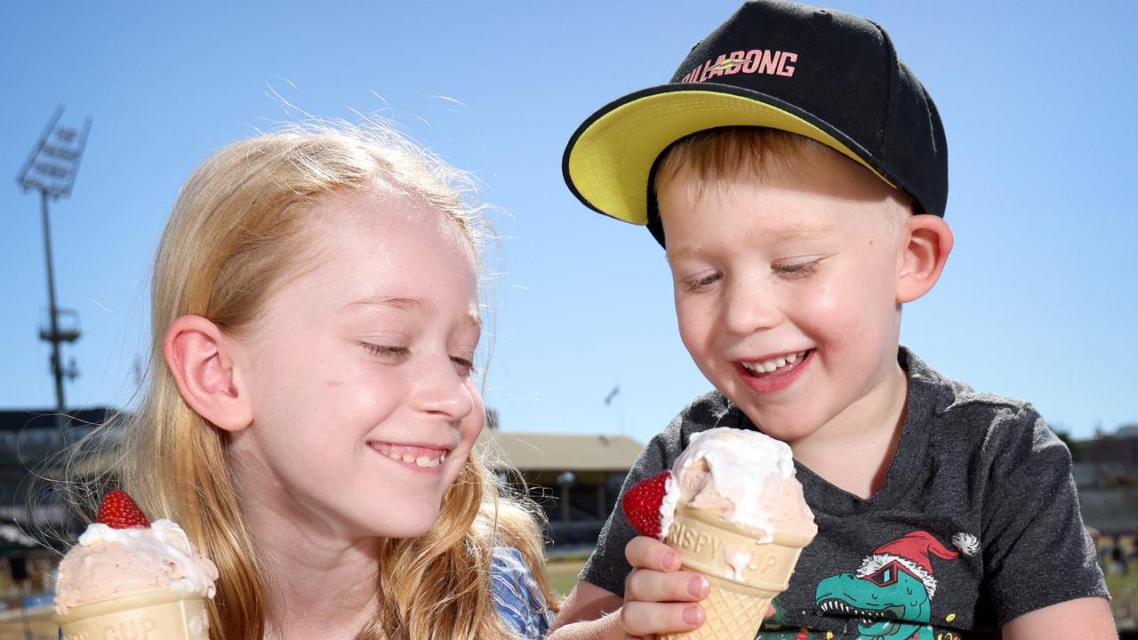 Kate Schipper 7 yrs Caleb Schipper 4 yrs, from Bellbird Park, eating Strawberry SundaeÃ&#149;s on the hill. Crowd, Strawberry sundae and dagwood dog contest photos, Ekka Bowen Hills, on Sunday 20th August 2023 - Photo Steve Pohlner