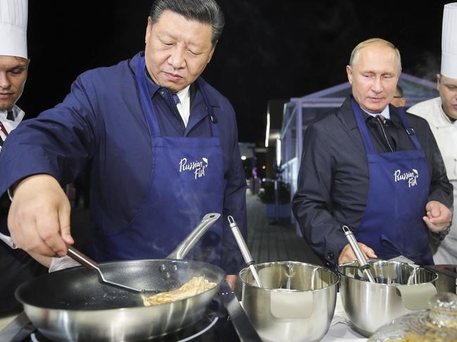 Chinese President Xi Jinping, second left, and Russian President Vladimir Putin, second right, prepare food, as they visit an exhibition during the Eastern Economic Forum in Vladivostok, Russia, Tuesday, Sept. 11, 2018. (Sergei Bobylev/TASS News Agency Pool Photo via AP)