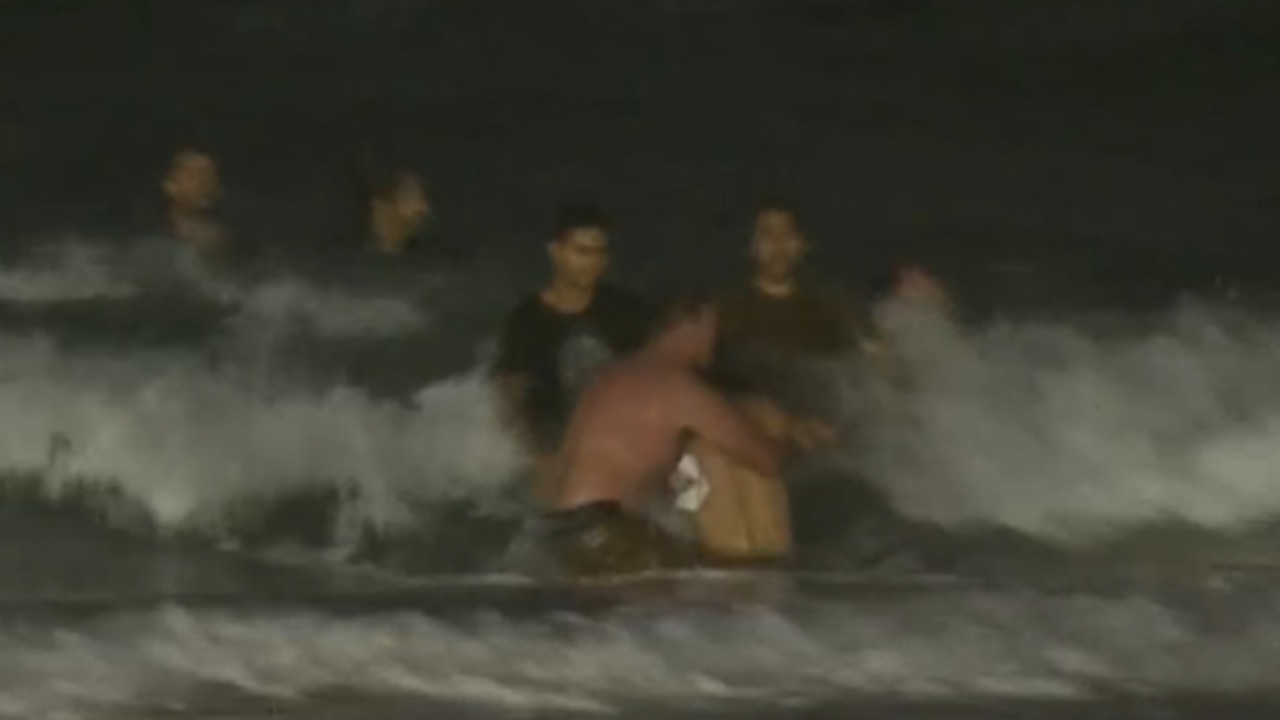 Paul Burt is seen with his shirt off, helping pull the young boy out of the water. Picture: 7 news