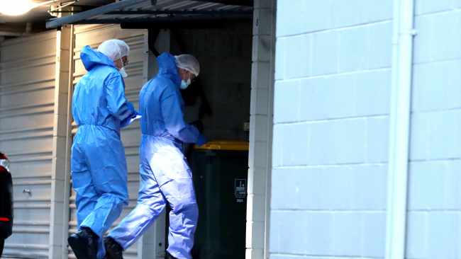 Forensic investigators enter the garage where the blue vehicle was found after police investigated electronic devices, they said. Picture: David Clark