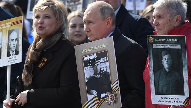 Russian President Vladimir Putin and other participants carry portraits of their relatives - WWII soldiers - as they take part in the Immortal Regiment march on Red Square in central Moscow. Picture: AFP