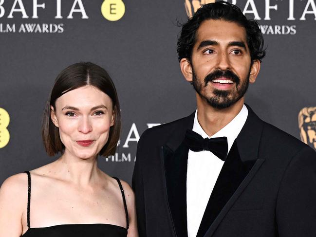 Dev Patel British actor and director poses alongside Australian actress Tilda Cobham-Hervey (L) on the red carpet upon arrival at the BAFTA British Academy Film Awards at the Royal Festival Hall, Southbank Centre, in London, on February 16, 2025. (Photo by Ben STANSALL / AFP)