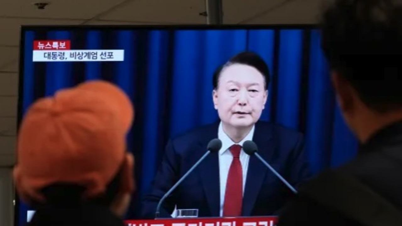 People watch a TV screen showing South Korean President Yoon Suk Yeol's televised briefing. Picture: AP