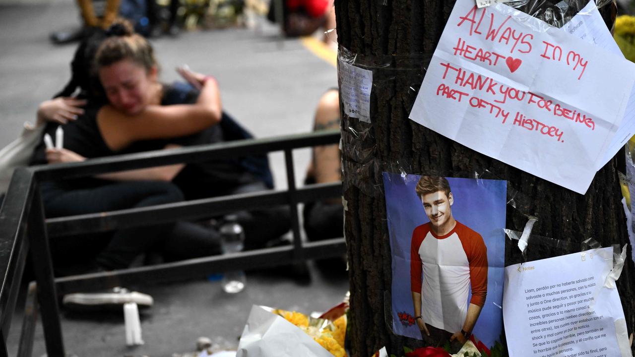 Fans pay tribute to British singer Liam Payne in front of the hotel where he died in Buenos Aires on October 17, 2024. Tributes poured in Thursday for British singer Liam Payne, a former member of the best-selling boy band One Direction, after he plunged to his death from the balcony of a Buenos Aires hotel. (Photo by Luis ROBAYO / AFP)